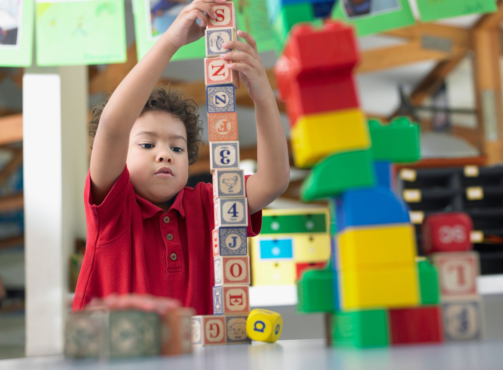 Preschool child learning through playing with stacking blocks.